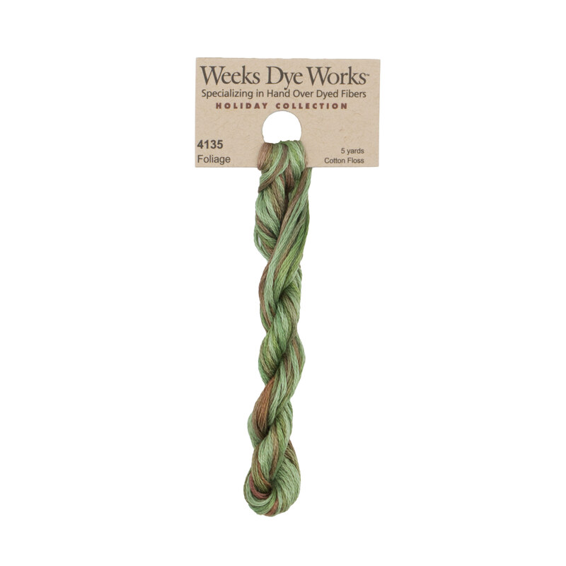 A skein of light kelly green and brown embroidery floss, twisted and bundled, with a tan label featuring the brand name and color information.