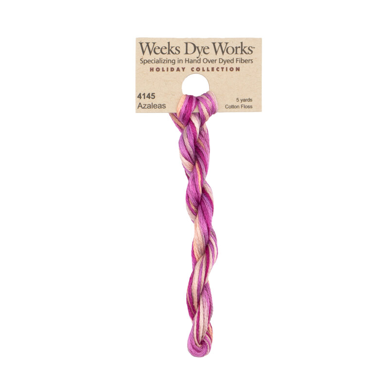 A skein of variegated pink and tan embroidery floss, twisted and bundled, with a tan label featuring the brand name and color information.