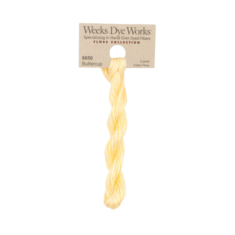 A skein of butter yellow embroidery floss, twisted and bundled, with a tan label featuring the brand name and color information.