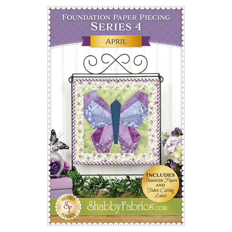 Front cover of the pattern showing the completed project in purple, periwinkle, green, and cream fabrics, hung on a craft display and staged with coordinating décor.