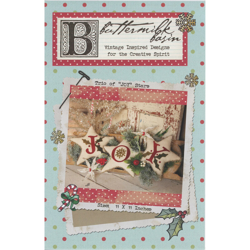 Front of the pattern showing the three completed stars in front of tree branches and other Christmas décor