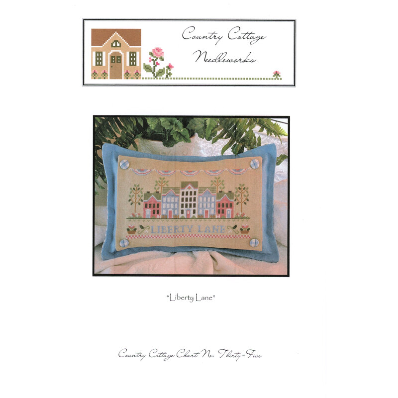 Image of a stitched pillow featuring colorful houses and the text Liberty Lane against a soft background.
