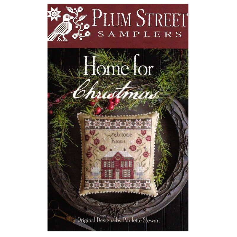 Front of pattern showing the completed cross stitch design finished as a pillow on a decorative plate with greenery.