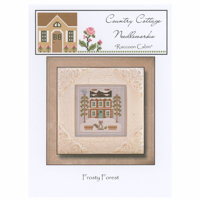The front of the Frosty Forest Raccoon Cabin pattern featuring a snowy cabin with a raccoon out front. 