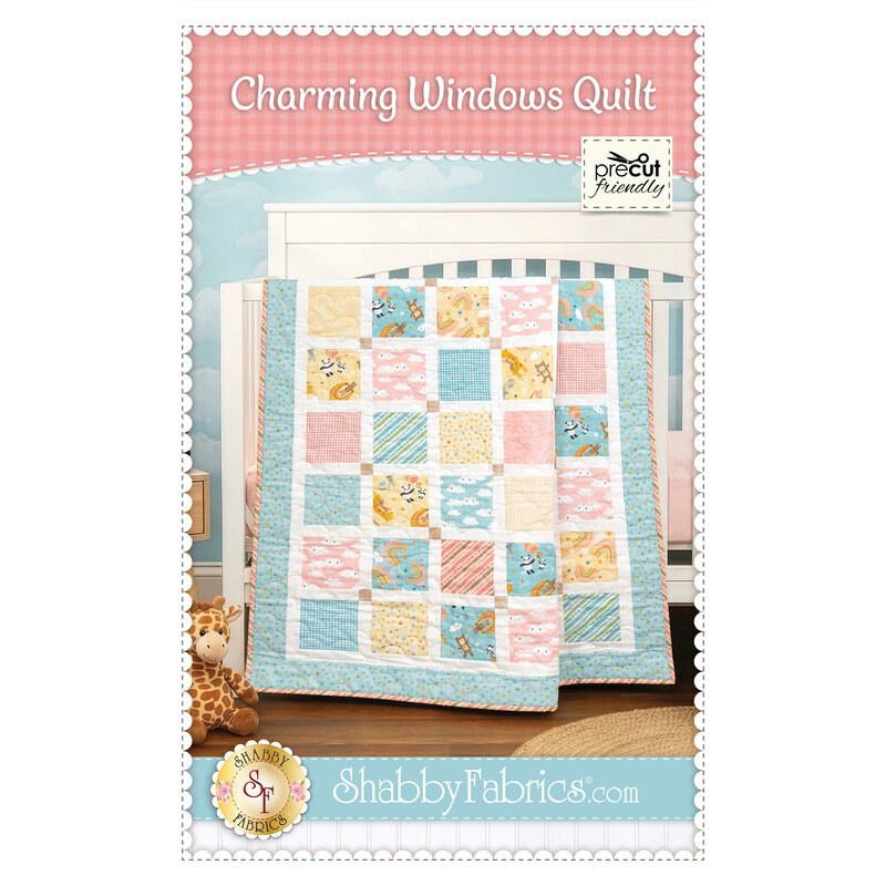 Front cover of the pattern showing the completed quilt colored in pastel primary colors from the Rainbow Dreams collection by Wilmington Prints, draped over a white crib in a nursey with coordinating décor.
