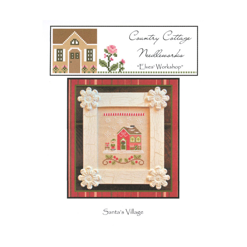 The front image of the "Elves' Workshop" cross stitch pattern featuring an elf with a present outside a workshop.