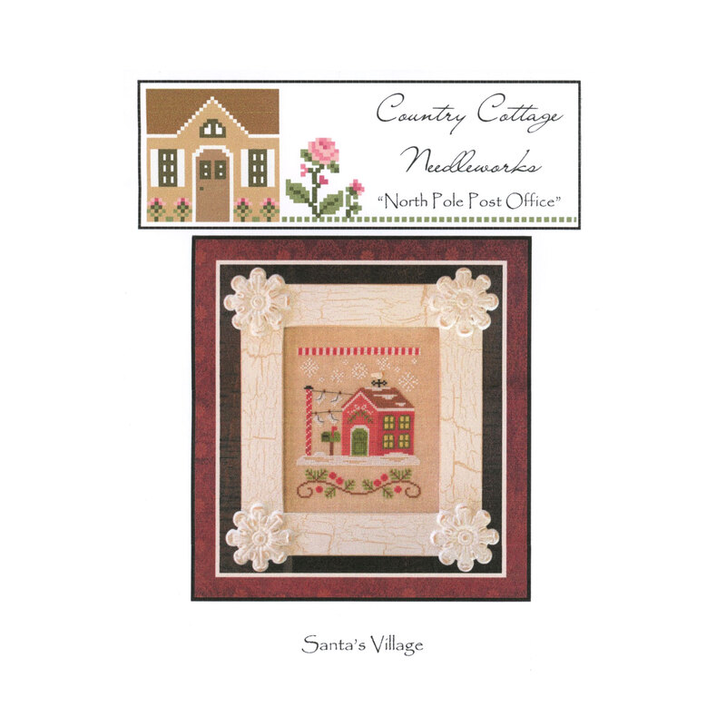 The front image of the "North Pole Post Office" cross stitch pattern featuring a snowy north pole post office.