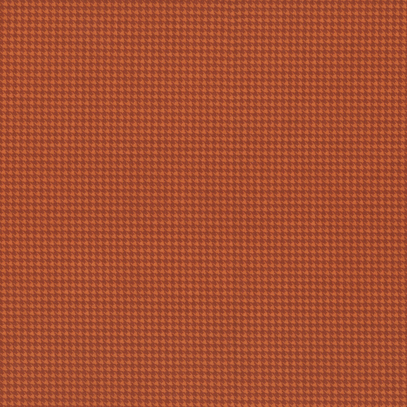 A houndstooth fabric swatch in tonal red hues.