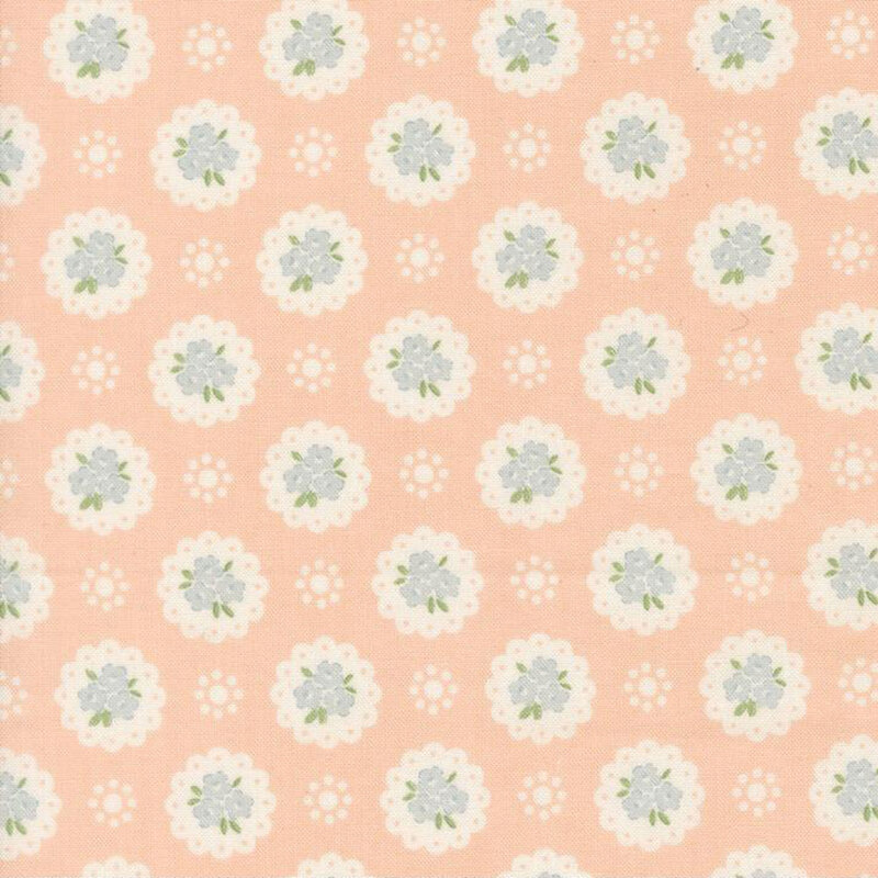 Light peach fabric with a pattern of white doilies containing light blue flowers and white dots
