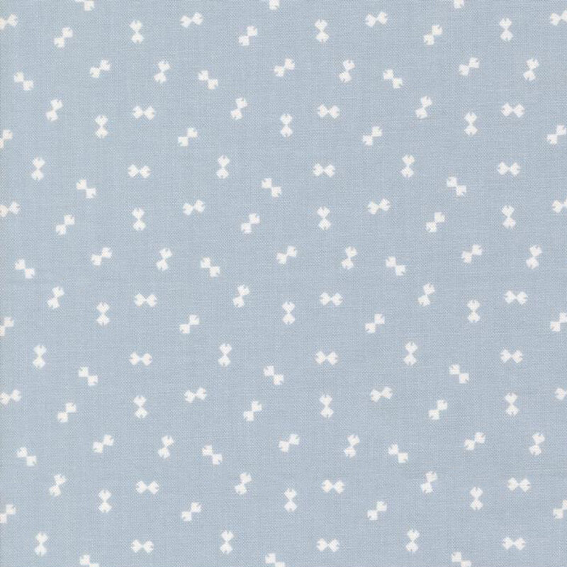 Baby blue fabric with a ditsy pattern of cream bowtie shapes.