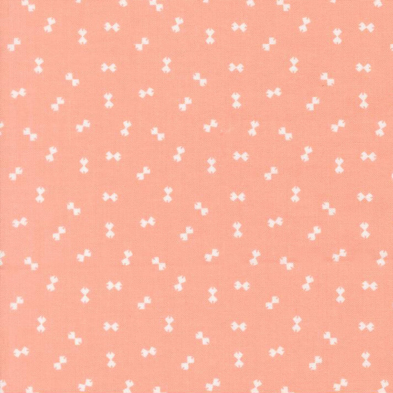Peach fabric with a ditsy pattern of white bowtie shapes.