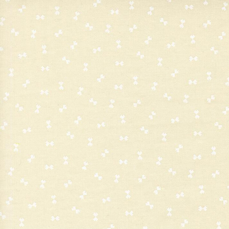 Cream fabric with a ditsy pattern of white bowtie shapes