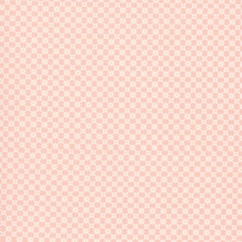 Pastel pink fabric with a cream pattern of circles and yellow dots