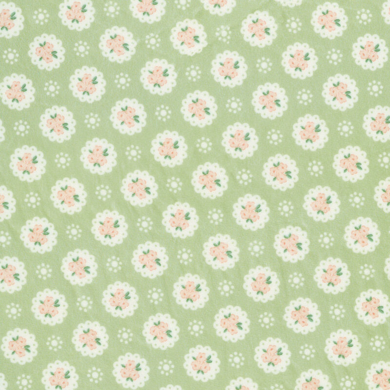 Pear green Quilting Cuddle fabric with a pattern of white doilies containing light peach flowers and white dots