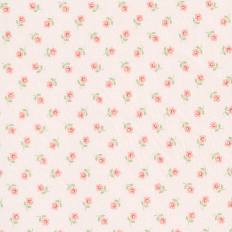 Ditsy pattern of peach flowers on a pastel pink Quilting Cuddle fabric.