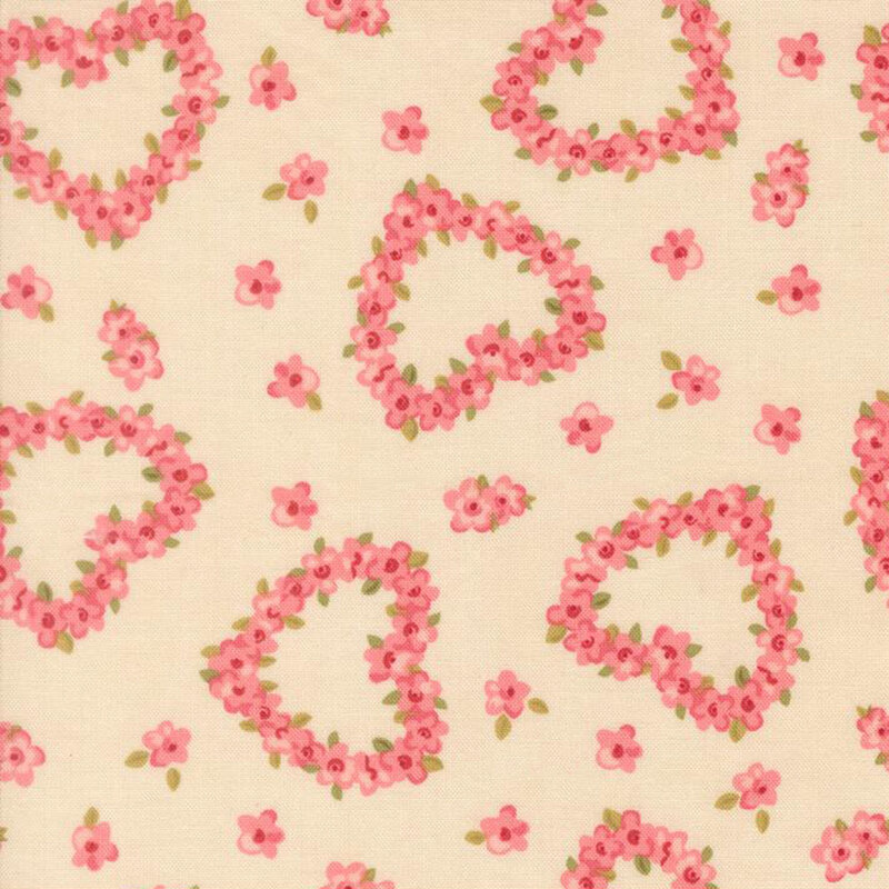 Pink roses in the shape of hearts tossed on a beige fabric with interspersed pink flowers