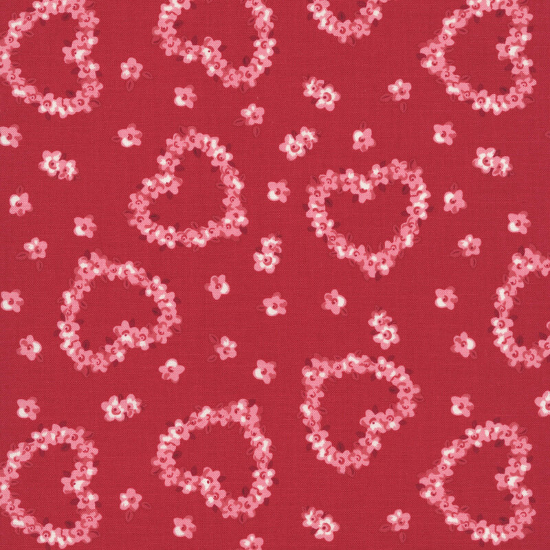 Pink roses in the shape of hearts tossed on lipstick red fabric with interspersed pink flowers