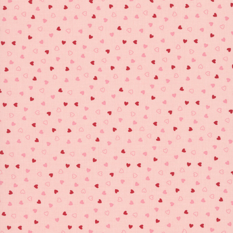 Tossed pink and red hearts on a blush pink background