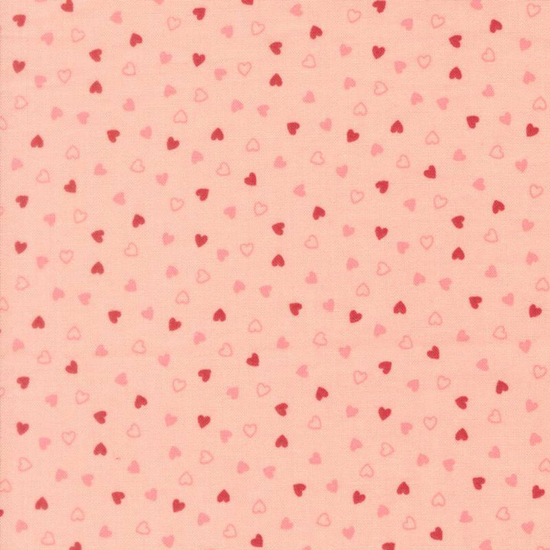 Tossed pink and red hearts on a blush pink background