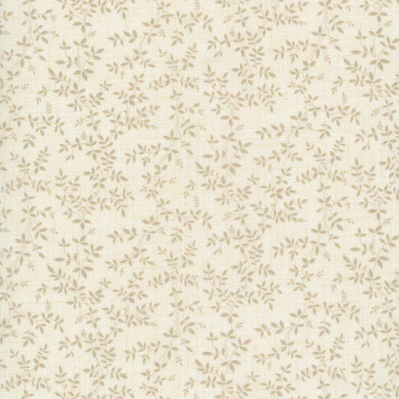 A fabric with a light cream background in a delicate pattern of small green and brown leaves.