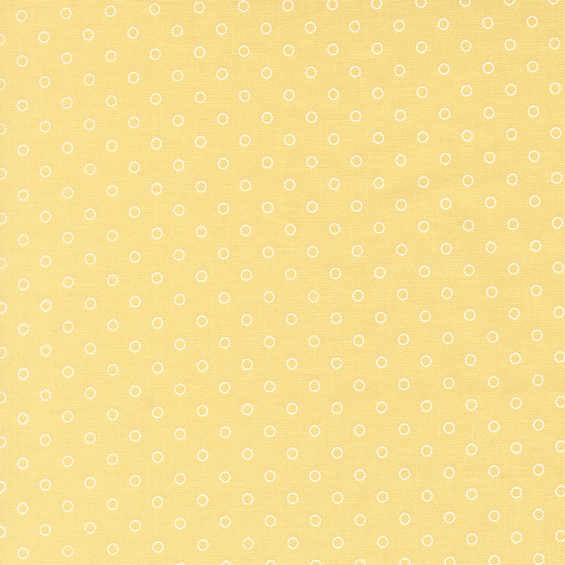 A butter yellow fabric with polka dots in a half drop pattern. 