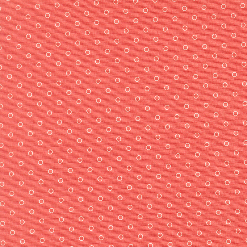A watermelon red fabric with polka dots in a half drop pattern. 