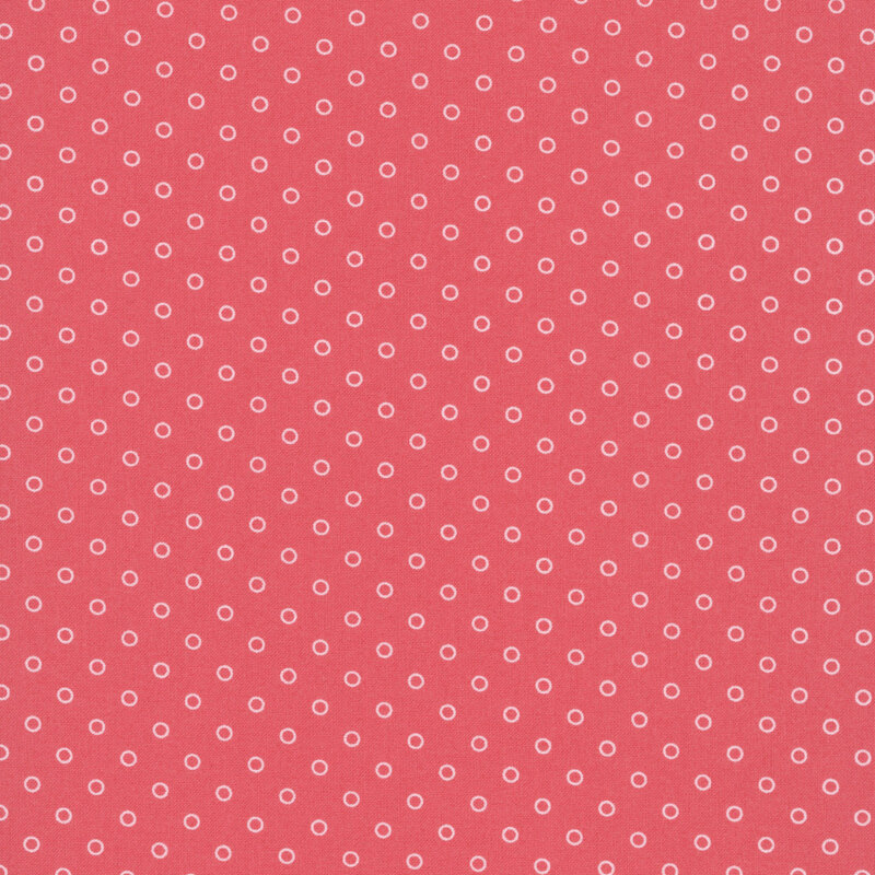 A watermelon red fabric with polka dots in a half drop pattern. 