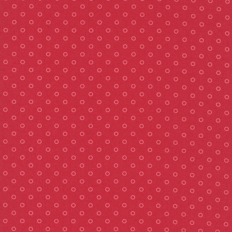 A ruby red fabric with polka dots in a half drop pattern. 