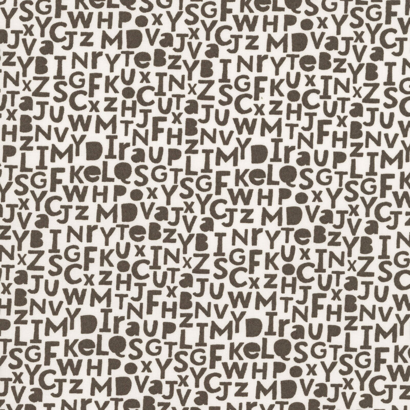 A light palomino fabric swatch featuring brown alphabet letters.