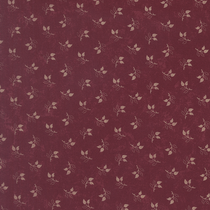 Mottled burgundy fabric featuring a tossed pattern of sprig leaves.