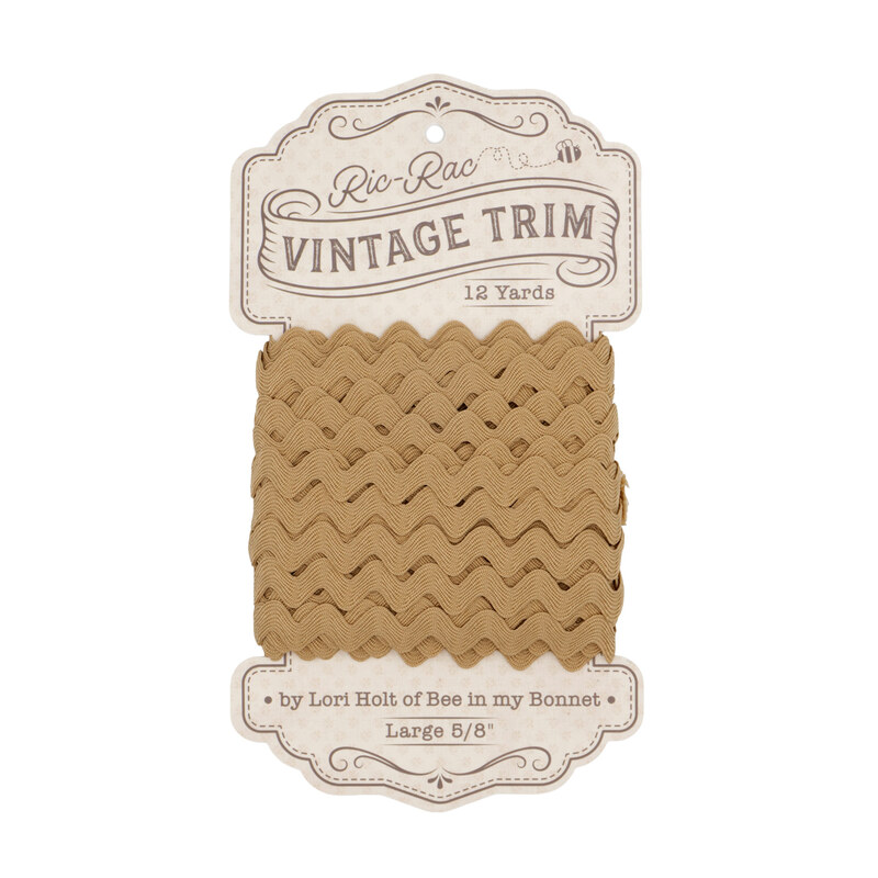 A spool of large camel tan ric-rac trim on a white background