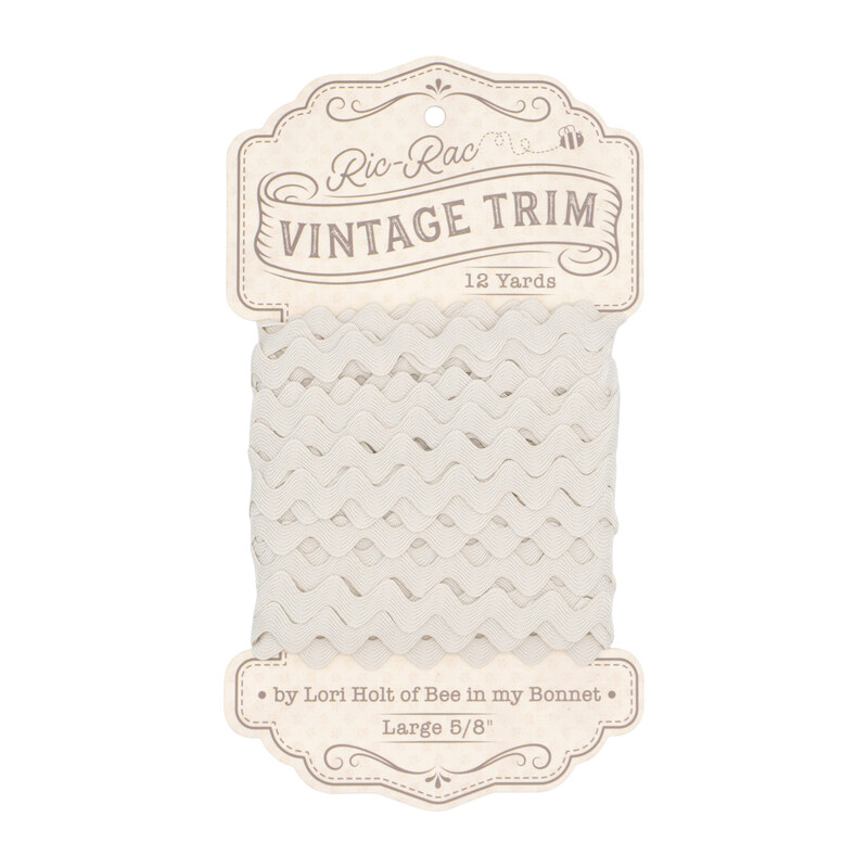 A spool of porcelain cream ric-rac trim on a white background