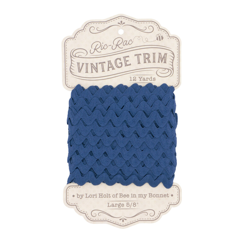 A spool of denim blue ric-rac trim on a white background