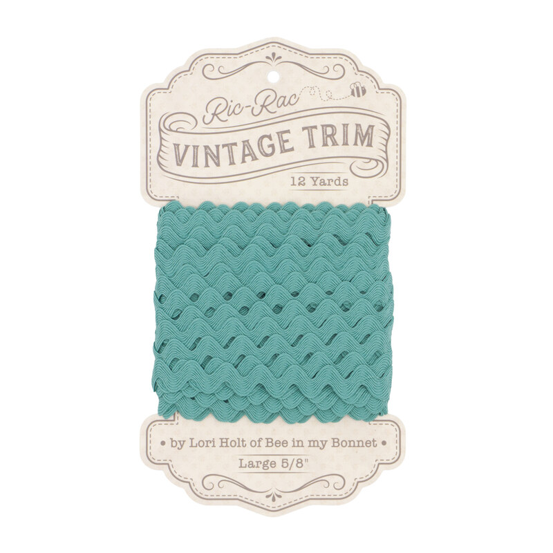 A spool of cottage blue ric-rac trim on a white background