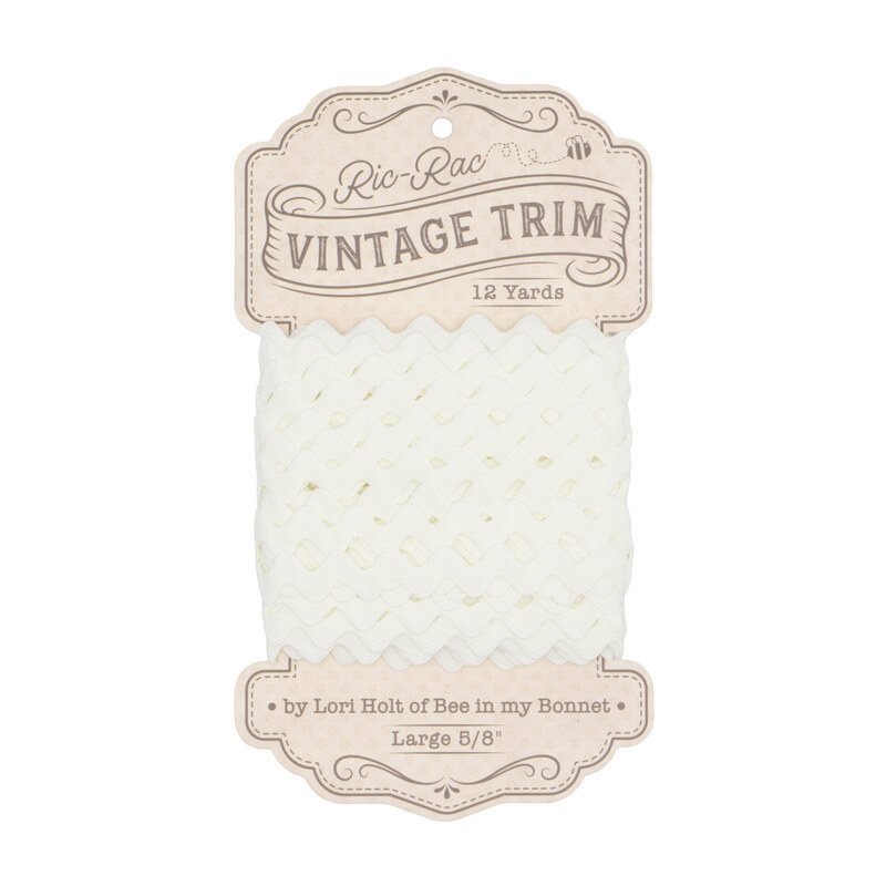 A spool of cloud white ric-rac trim on a white background