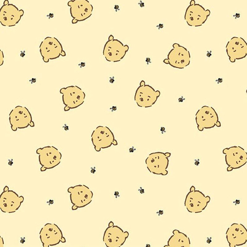 Soft yellow fabric with a playful pattern of cartoon Winnie the Pooh faces and small bumblebees.