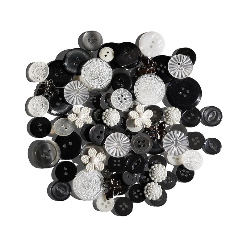 A scattered collection of various black, white, and gray buttons in different sizes and styles.