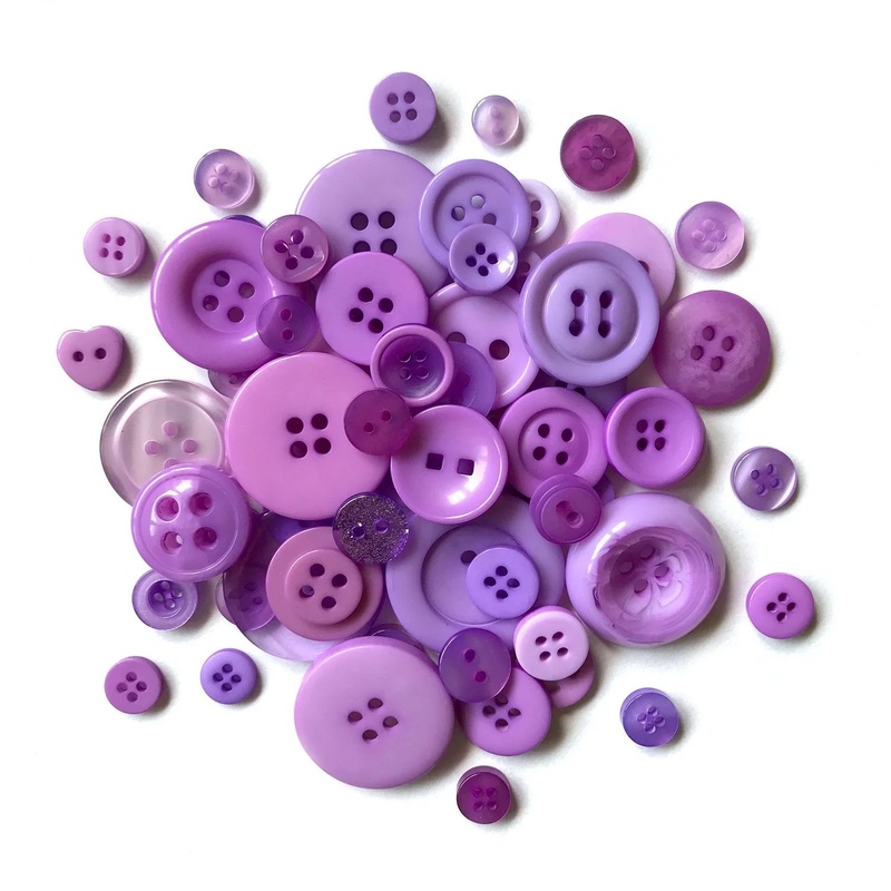 A pile of purple themed buttons in a variety of sizes.