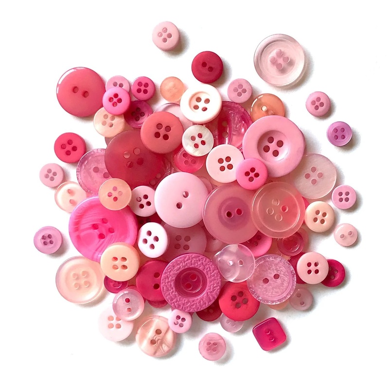 A pile of pink buttons in a variety of sizes.