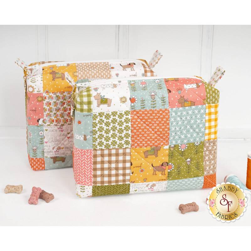 The two completed Mini-Charm Bags, colored in vibrant fabrics from the Lucky collection by Moda Fabrics and staged on a clean white countertop with coordinating décor.