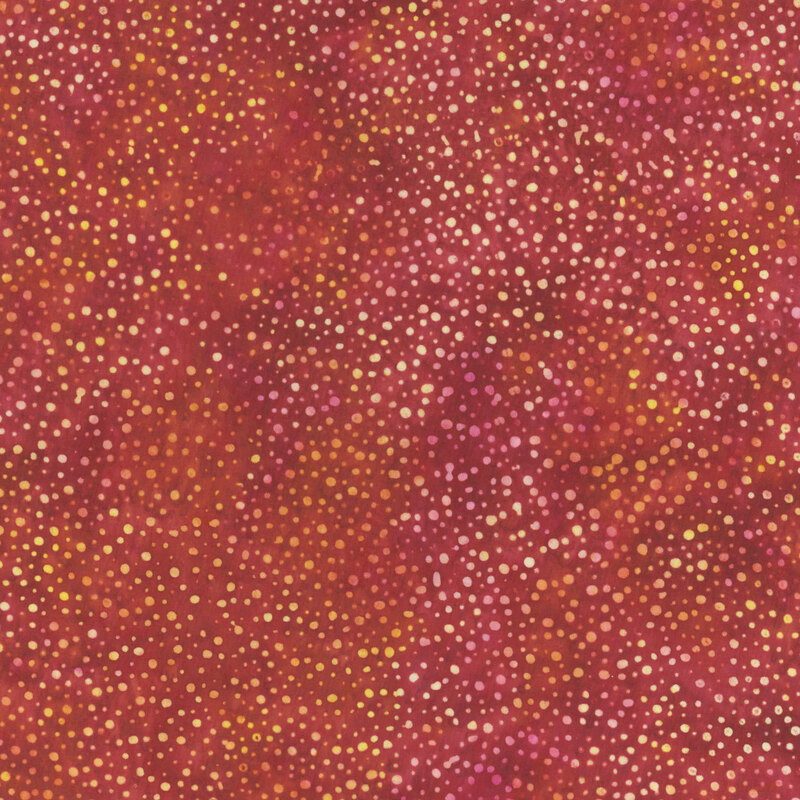 A mottled tomato red batik fabric with scattered yellow dots.