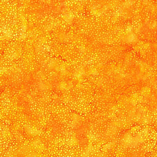 A mottled bright marigold yellow batik fabric with scattered tonal dots.