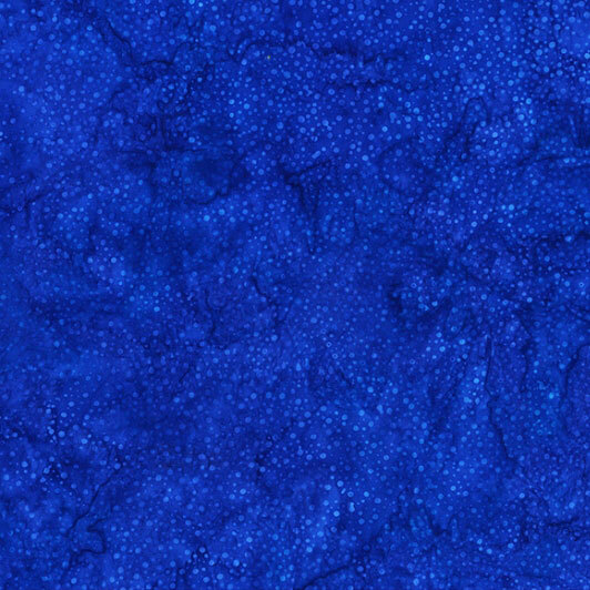 A mottled bright ultramarine blue batik fabric with scattered tonal dots.