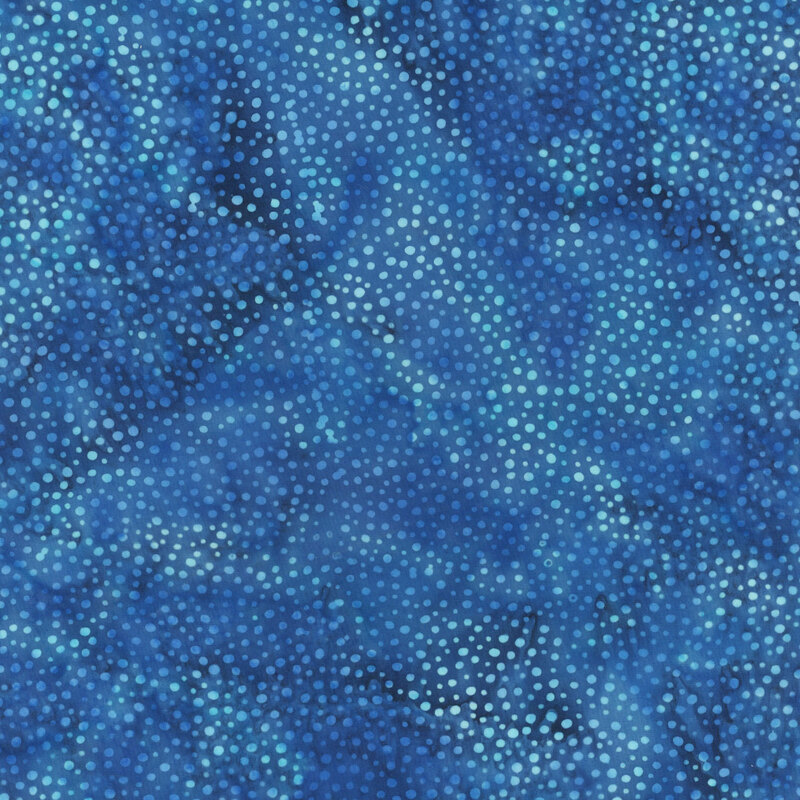 A mottled sapphire blue batik fabric with scattered light blue dots.
