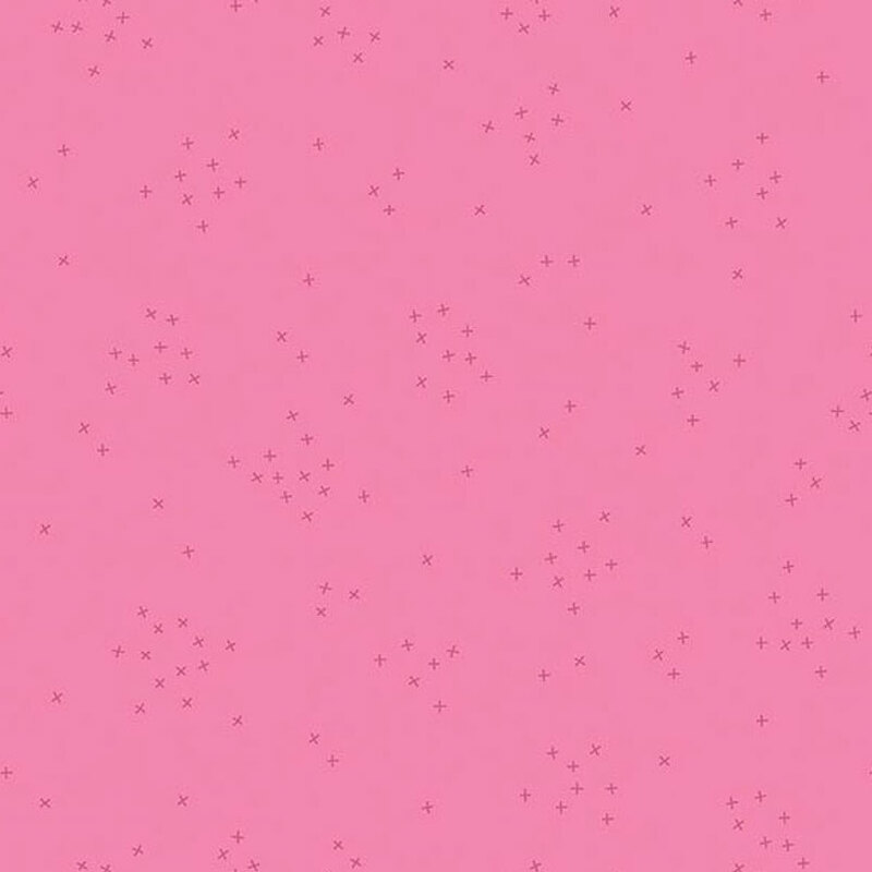 This rose pink fabric is scattered with tiny tonal crosses clustered together.