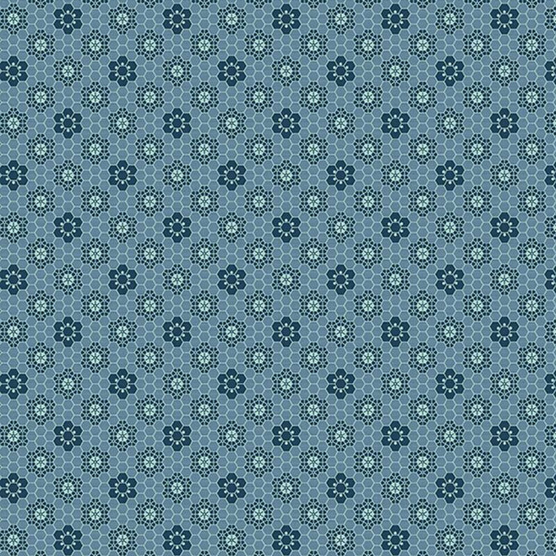 Denim blue fabric with a tonal honeycomb texture and navy blue geometric floral designs