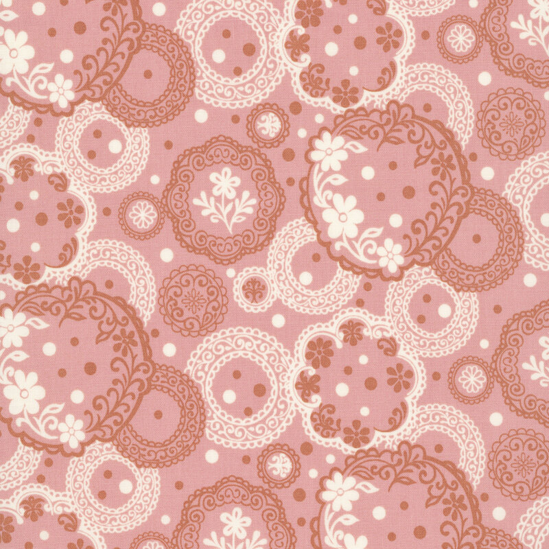 Ornate pattern of gray and pink circular medallions filled with lace-like details, florals, and dotted accents on a beige background.