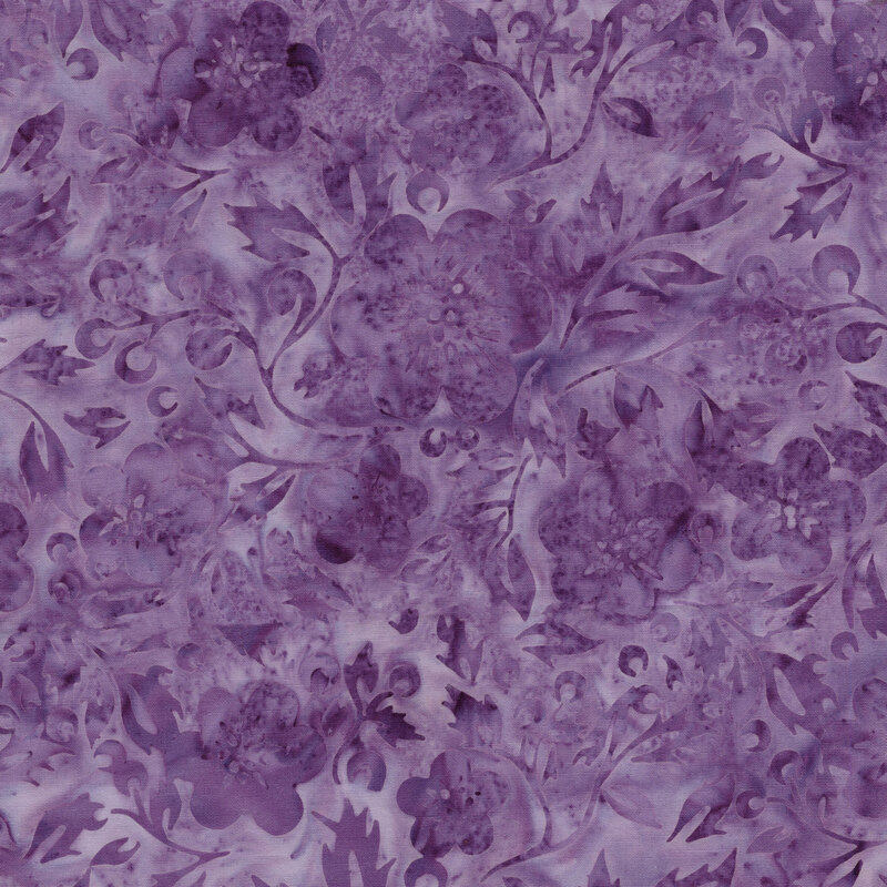 A mottled grape purple batik fabric with tonal flowers and leaves. 