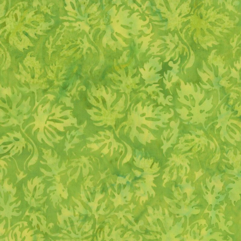A mottled lime green batik fabric with tonal leaves. 