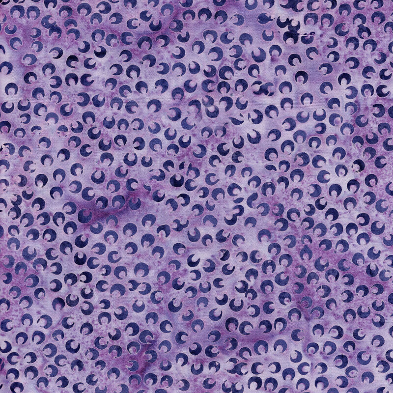 A mottled hyacinth batik fabric with scattered dark purple petals. 